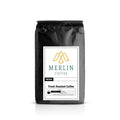 Black bag of fresh roasted coffee beans with Merlin Coffee label